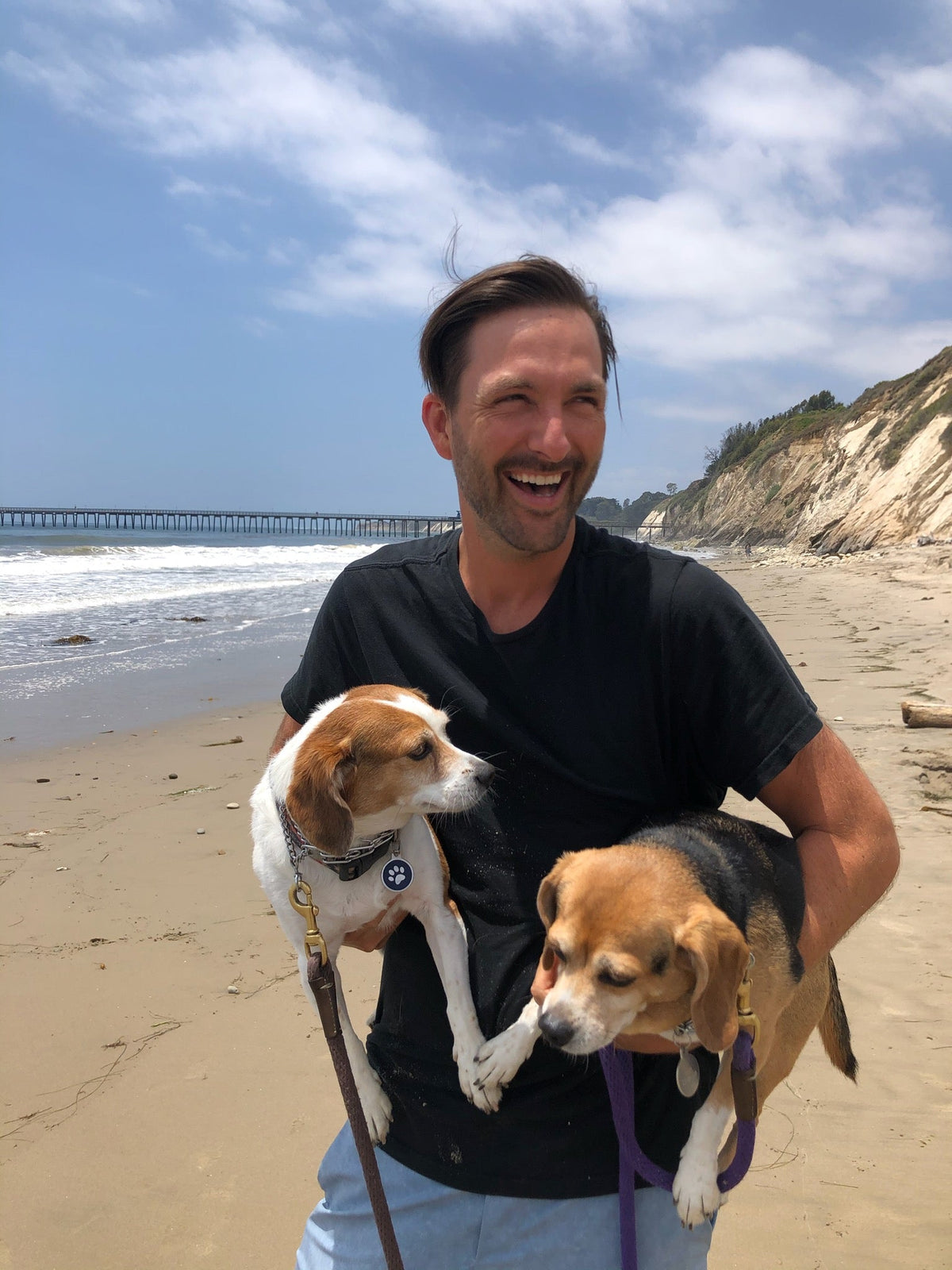 Photo of Seth Jennemann on the beach with dogs. MEFREEK