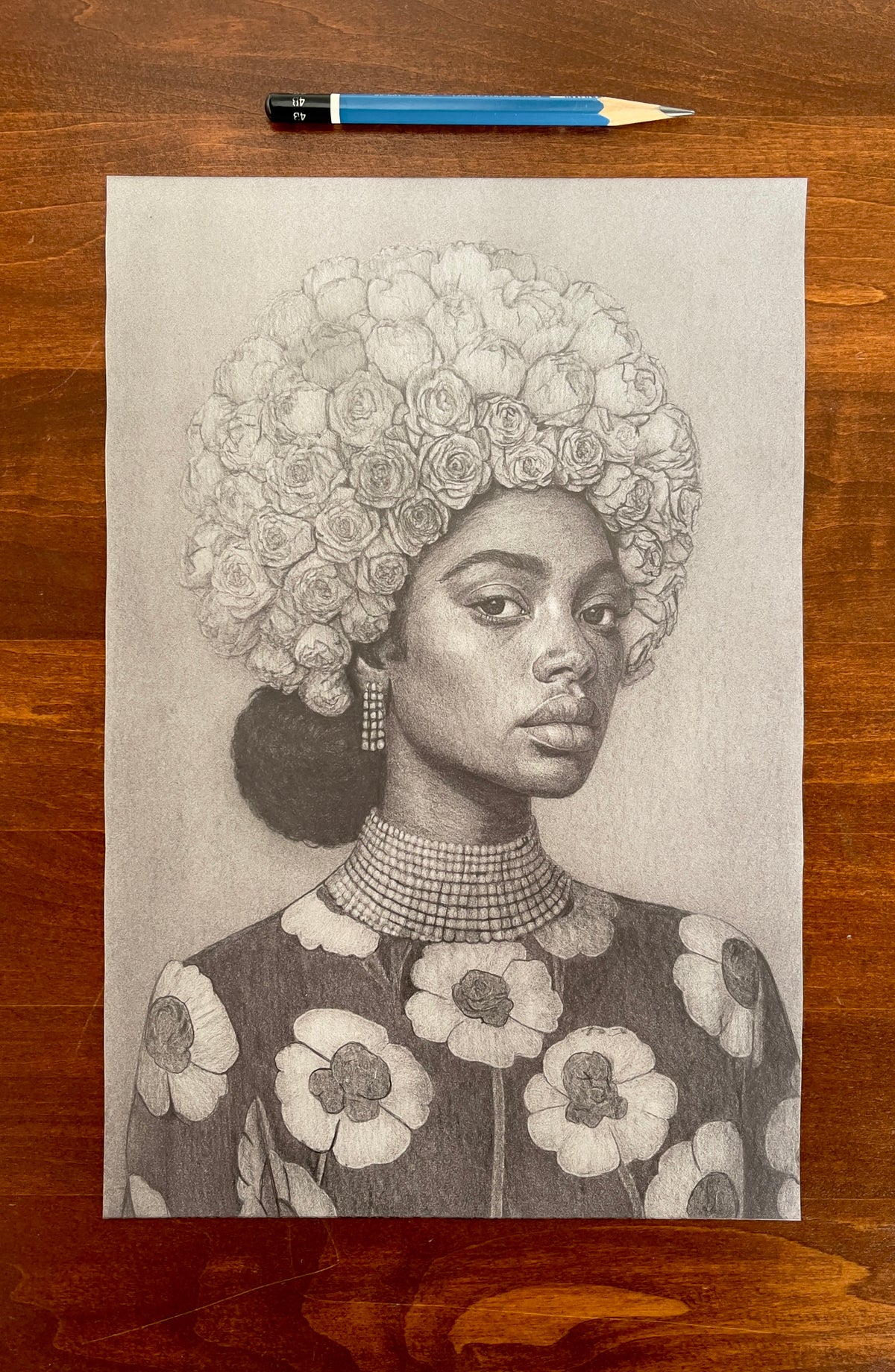 Seth Jennemann MEFREEK — A Smile That Came With Strings Attached, graphite pencil drawing in hyperreal contemporary portrait style. A woman with a crown of roses for hair and a floral-patterned dress gazes confidently at the viewer, framed by intricate shading and delicate realism.