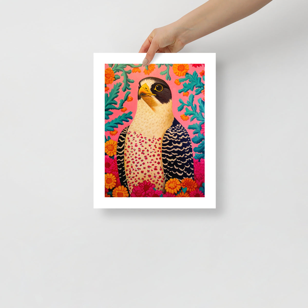 MEFREEK Seth Jennemann Open Edition Print “Claws For Concern” — vibrant contemporary artwork of a peregrine falcon with floral patterns on a pink background, shown unframed as a person holds the fine art print for scale.