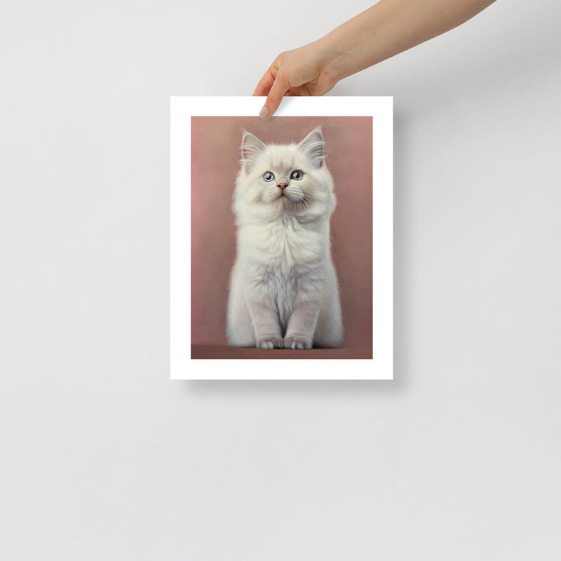 MEFREEK Seth Jennemann Open Edition Print "I Bought Him Toys But He Plays With A Ghost" fine art print held by a hand, white fluffy kitten centered against pink tones, hyperreal detail, matte paper with white border for framing.