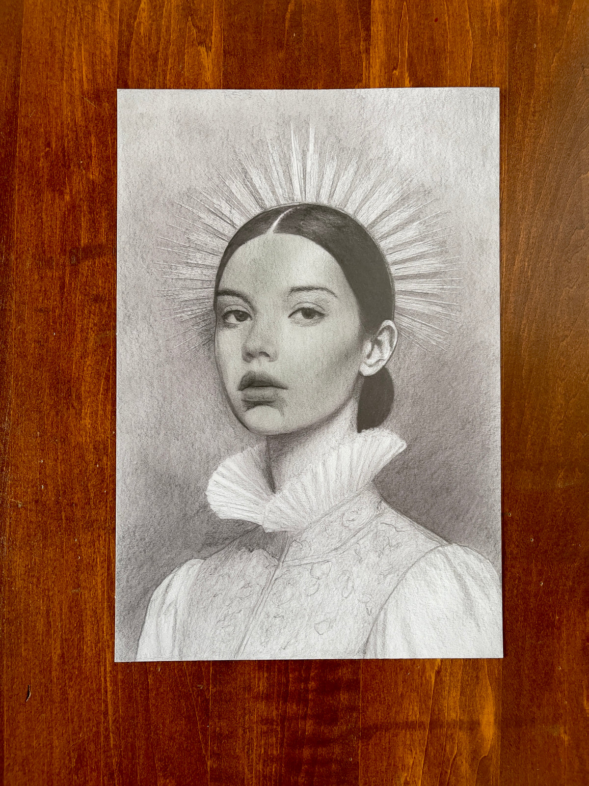 Seth Jennemann MEFREEK — I Said Nothing, So They Heard What They Wanted, graphite pencil drawing in hyperreal contemporary portrait style. A woman with sleek hair and a pleated ruff collar gazes forward beneath a glowing halo of radiant lines, blending quiet defiance with classical reverence.