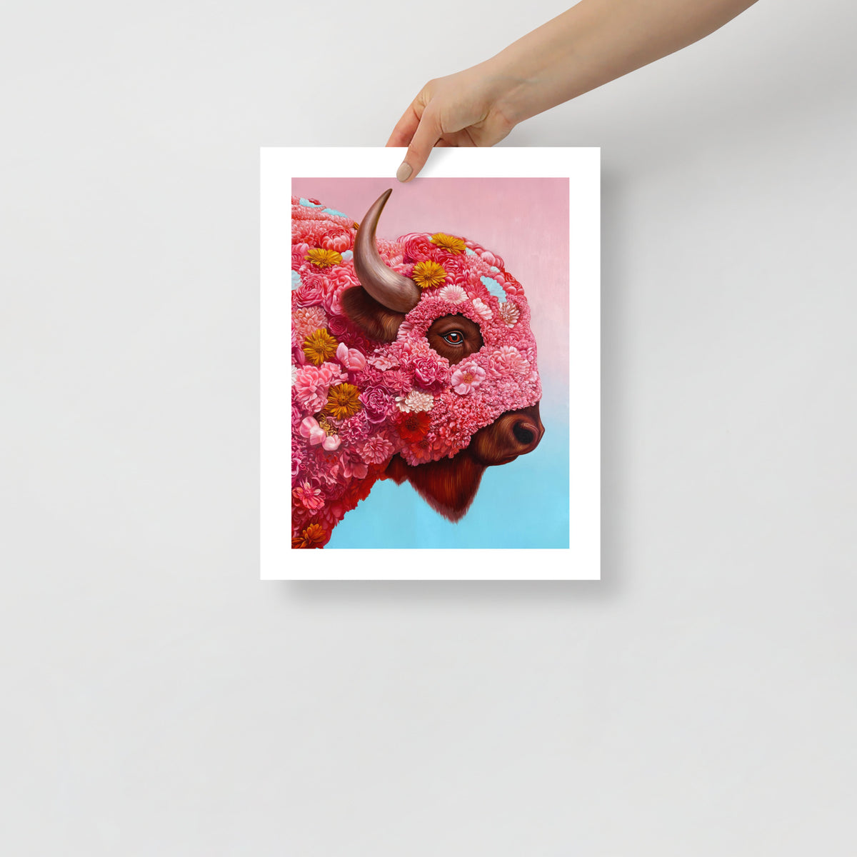 MEFREEK Seth Jennemann Open Edition Print hyper realistic floral bison portrait with intricate pink blossoms forming the animal’s face, detailed horn and expressive eye, shown as a physical fine art print held by a hand against a clean minimal background