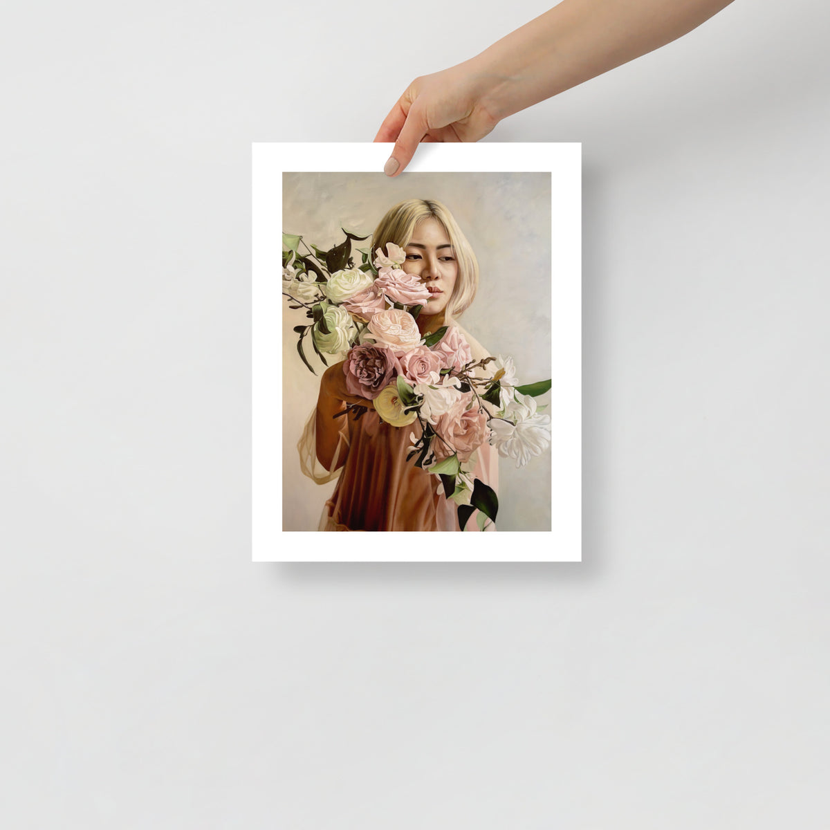 MEFREEK Seth Jennemann Open Edition Print “Lizzie” — contemporary oil-style artwork featuring a blonde woman gazing downward through a cascade of roses and lilies in soft pastel tones, shown unframed and held for scale.