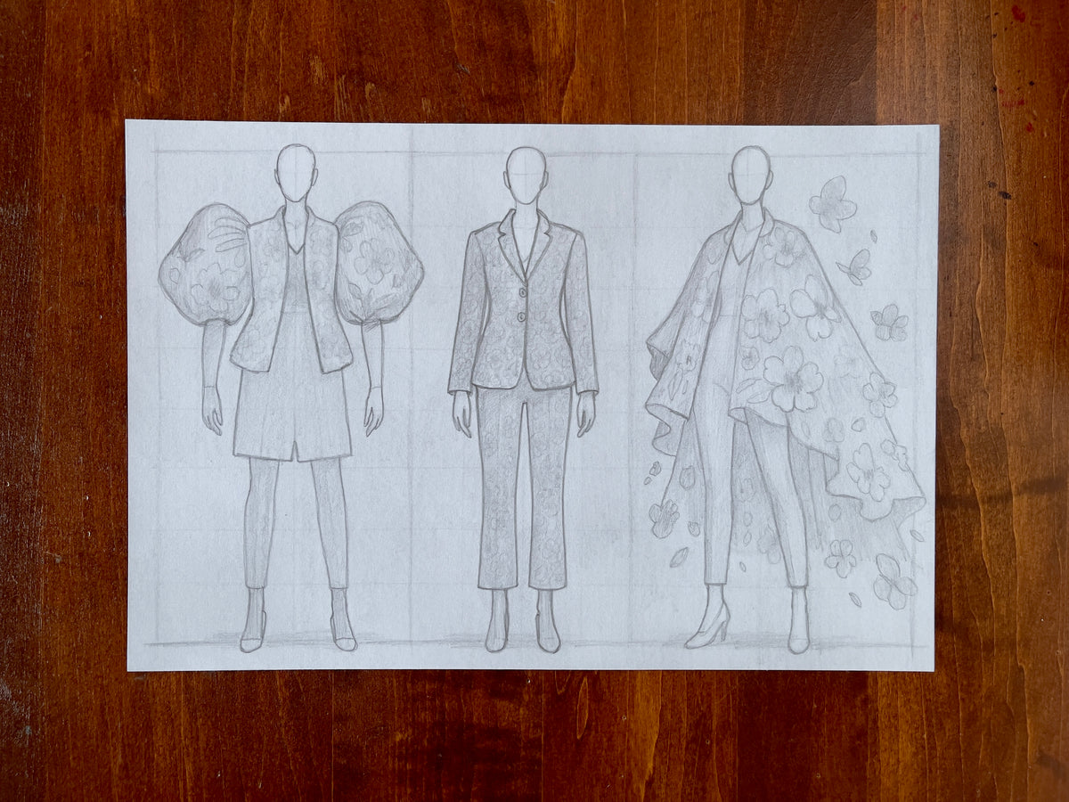 Seth Jennemann MEFREEK Now With Less Feeling – pencil drawing in contemporary fashion illustration style featuring three faceless croquis figures wearing floral-patterned tailored outfits, from puff-sleeved jackets to flowing capes, symbolizing transformation through structure and bloom.
