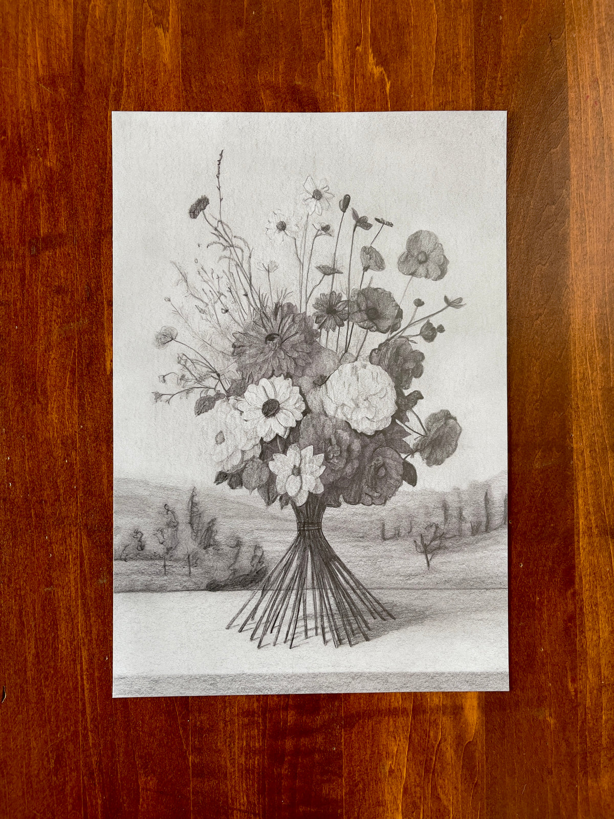 Seth Jennemann MEFREEK Small Catastrophes In The Courtship Of Edwin Brash – graphite drawing in a hyperreal surrealist style depicting a lush bouquet of wildflowers balanced on thin wire-like stems against a soft landscape background with trees and distant hills.
