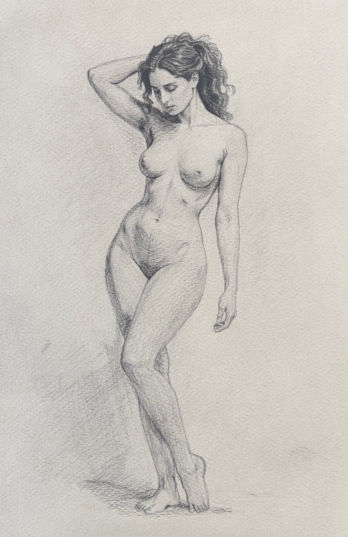 MEFREEK Seth Jennemann Graphite Pencil Figure Drawing Study of a standing nude female in contrapposto pose with subtle curve and weight shift highlighting natural anatomy soft shading and elegant posture on textured paper