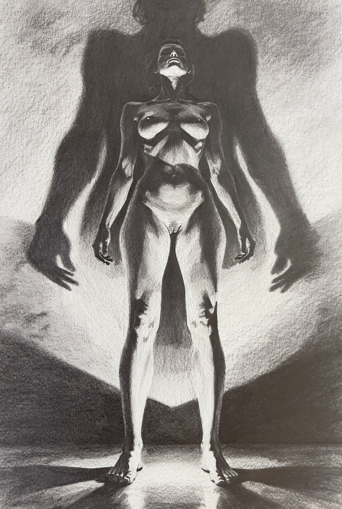 MEFREEK Seth Jennemann High Contrast Graphite Drawing of a standing nude female figure illuminated from below casting a large dramatic shadow silhouette behind her emphasizing anatomy form and bold chiaroscuro lighting on textured paper