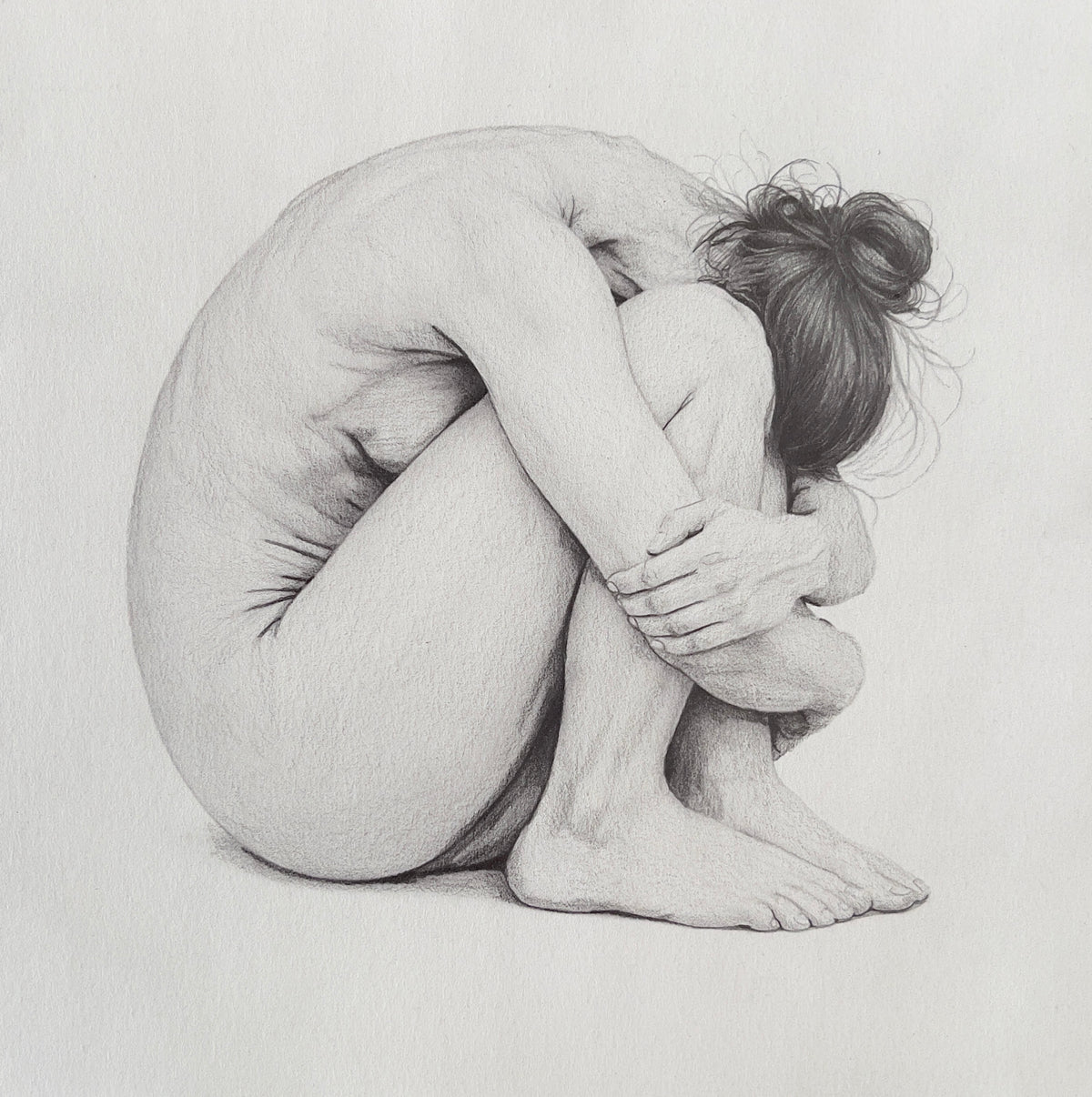 MEFREEK Seth Jennemann Graphite Pencil Drawing of a curled nude female figure seated in a tightly folded pose with knees drawn to chest and arms wrapped around legs, rendered in soft grayscale with delicate anatomical precision, subtle shading, and intimate lighting that emphasizes form, vulnerability, and quiet introspection