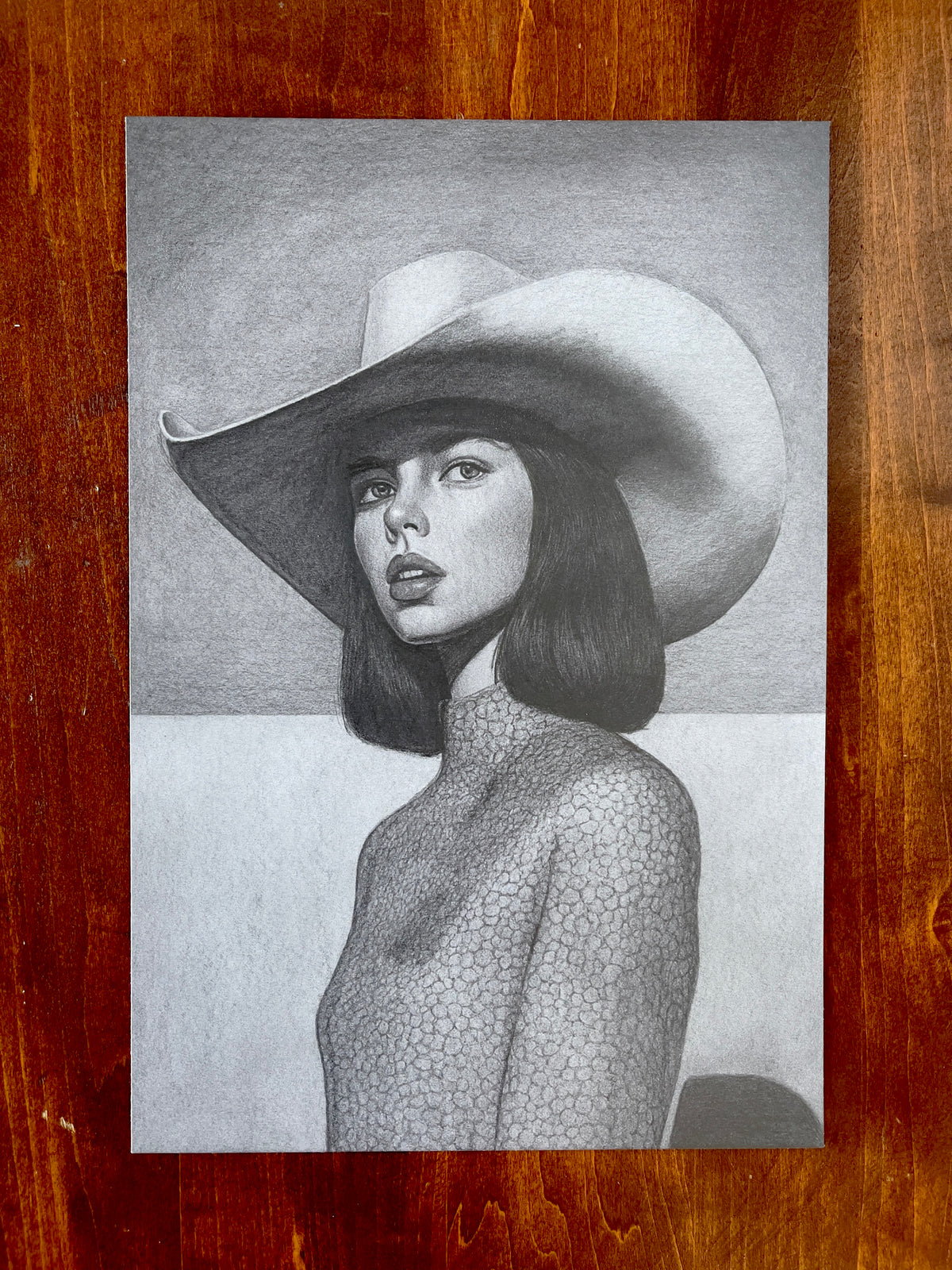 Seth Jennemann MEFREEK Synthetic Sunset For A Lonely Rodeo – graphite drawing in hyperreal pop surrealism style depicting a woman in a wide-brimmed cowboy hat and textured high-neck top, evoking cinematic western nostalgia with futuristic elegance.
