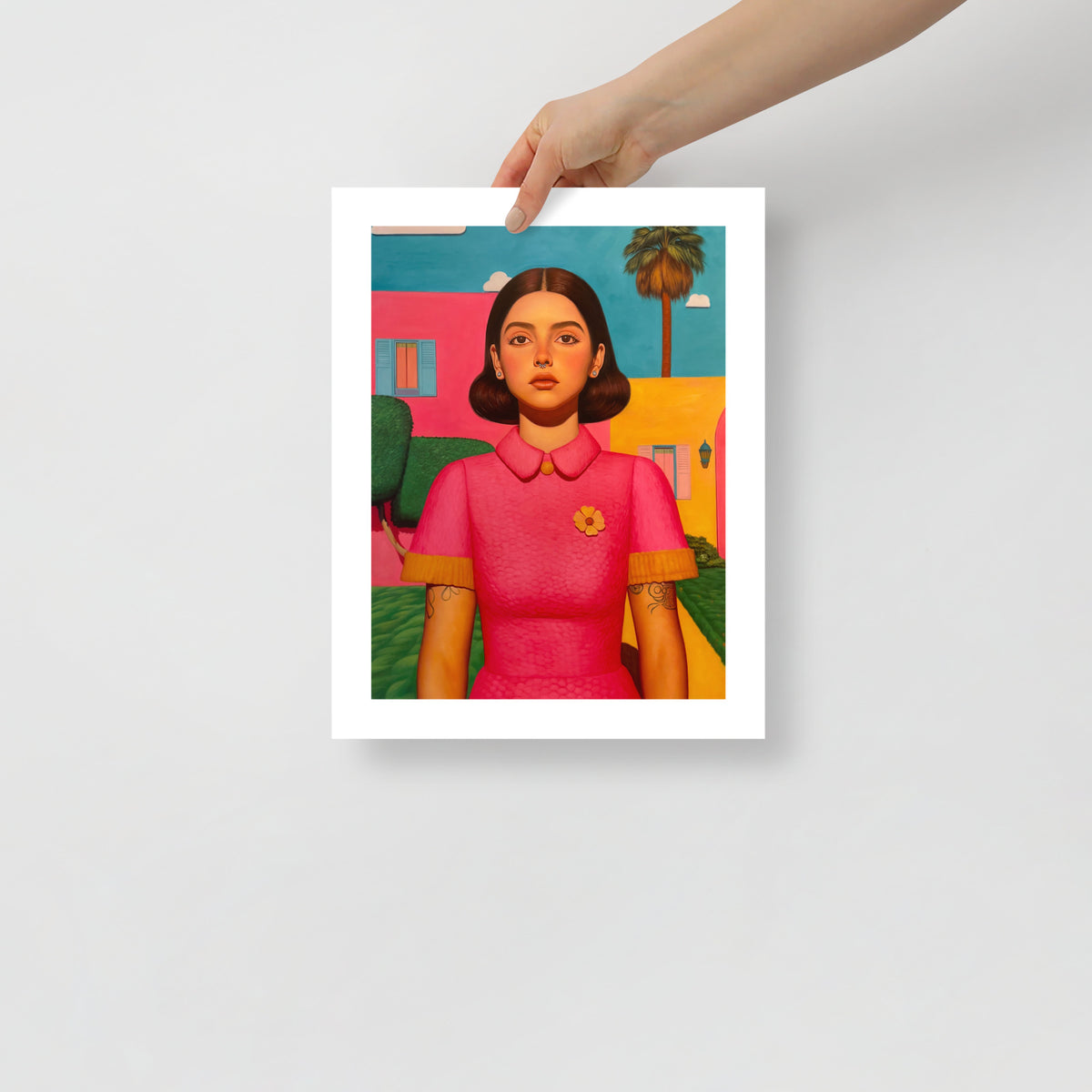 MEFREEK Seth Jennemann Open Edition Print This Only Ends When You Do fine art portrait of a woman with dark brown hair and expressionless face, wearing a pink textured dress in front of blue, yellow, and pink architecture, modern pop surrealist realism emphasizing digital stillness.