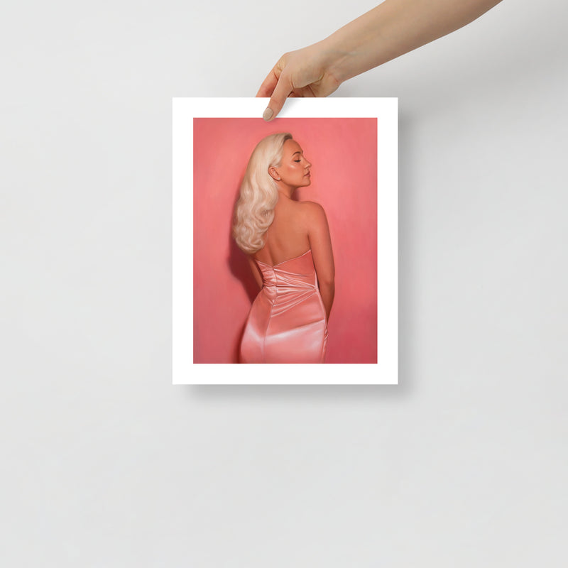 MEFREEK Seth Jennemann Open Edition Art Prints Two For The Price Of Two – Unframed fine art print held by hand against a light gray background, featuring a glamorous blonde woman viewed from behind in a shimmering strapless pink satin dress, with long platinum waves, closed eyes, and a vibrant pink backdrop.