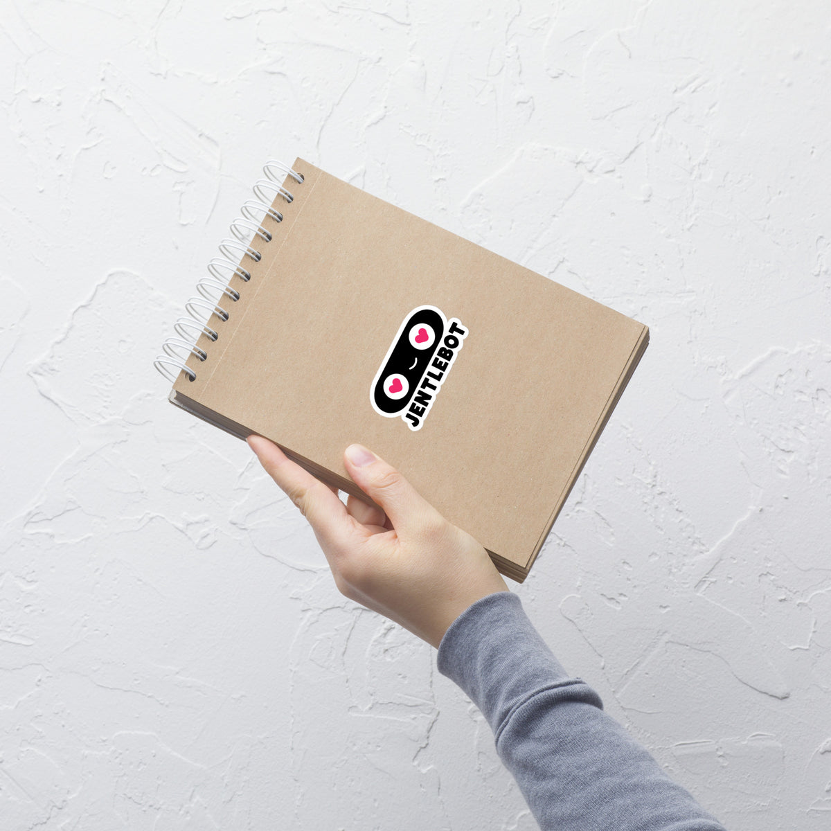 Hand holding a brown notebook with a textured white background