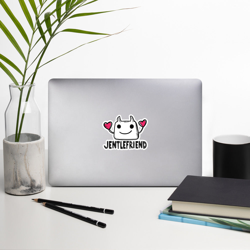 Laptop with a sticker on a desk with a plant, pencils, and books.